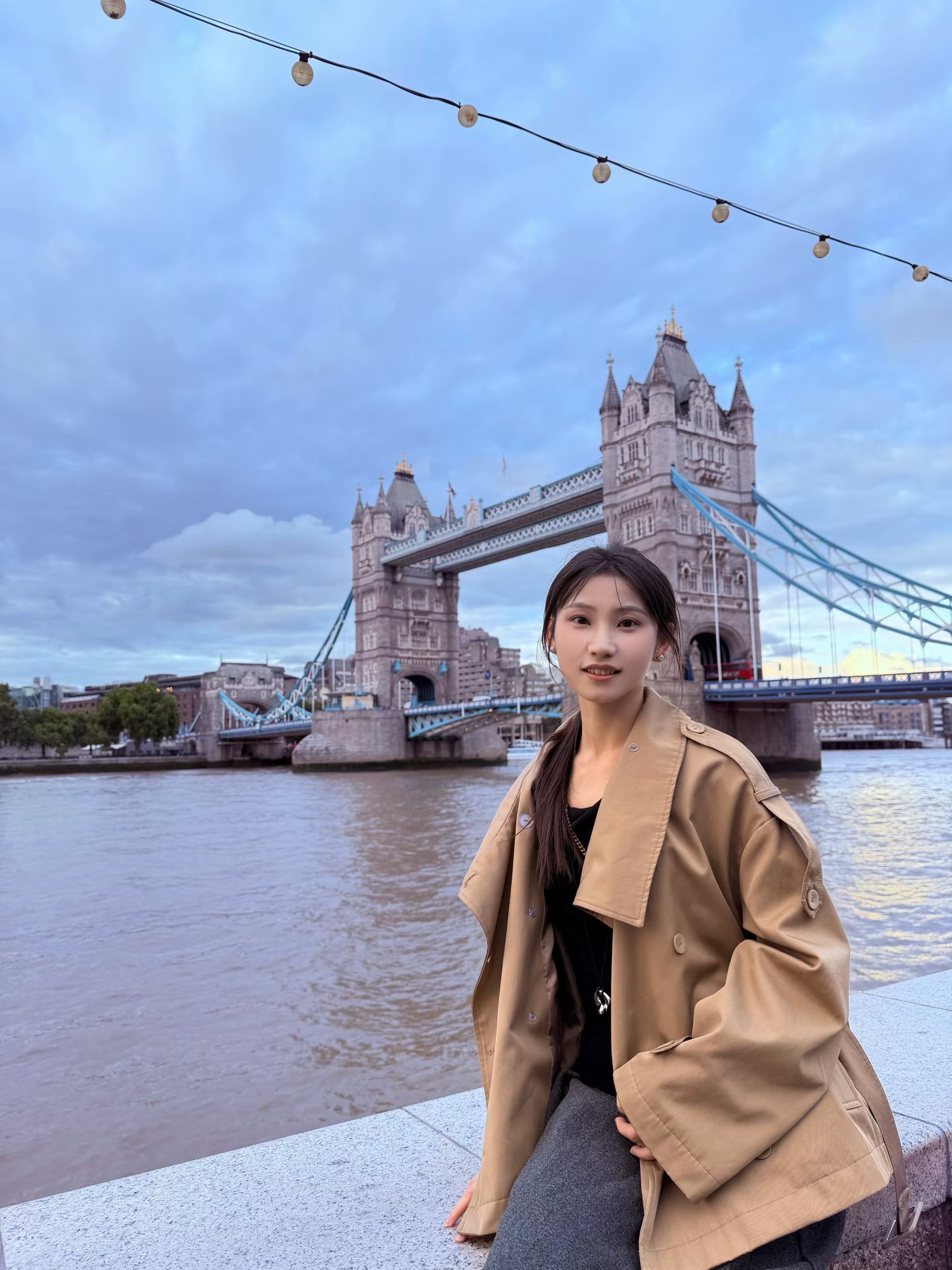 泰晤士河畔的伦敦塔桥与一位穿风衣的女孩